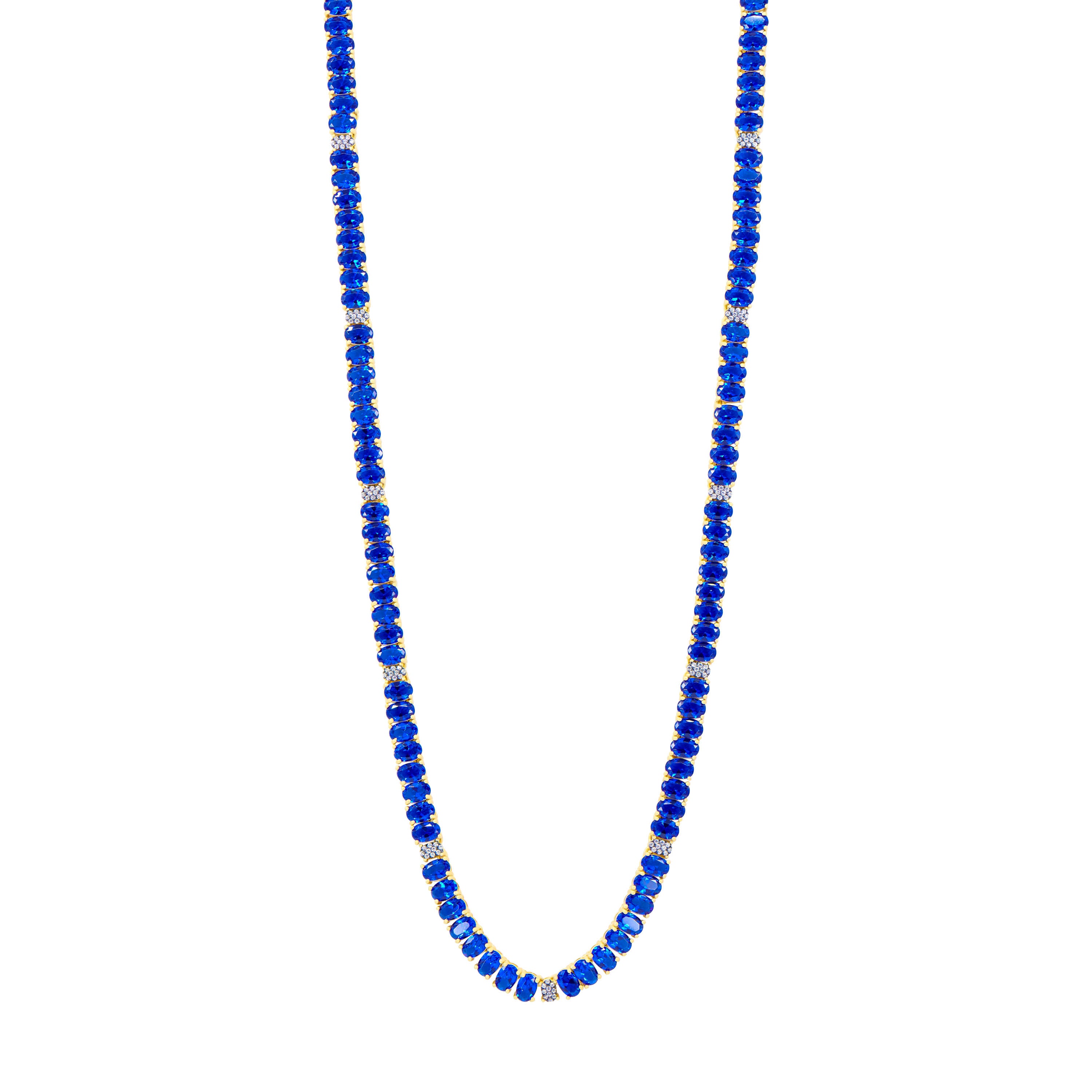 The Midnight Tri-Tone Twilight Oval Station Tennis Necklace by Midnight showcases deep blue beads alternating with 14K matte gold spacers, creating an elegant and evenly spaced design. The uniformly shaped blue beads are beautifully complemented by the small gold spacers, all set against a white background.